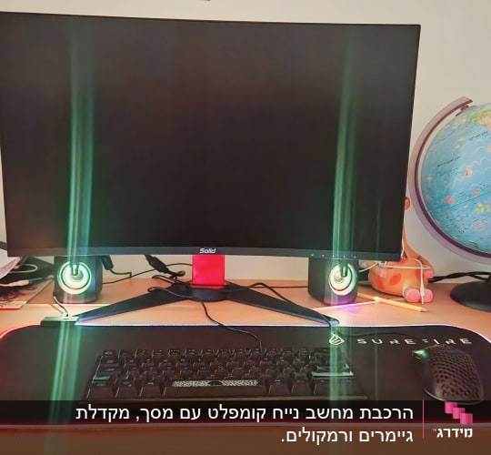 מסך מחשב, מקלדת, עכבר ומשטח מואר על שולחן